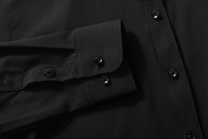 Macro detail of the fabric texture and black four-hole buttons on the long sleeve shirt