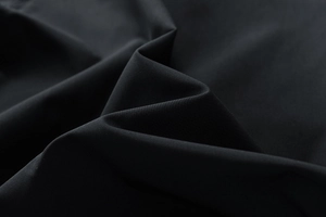 Détail macro de la veste coupe-vent noire avec texture textile fine et souple
