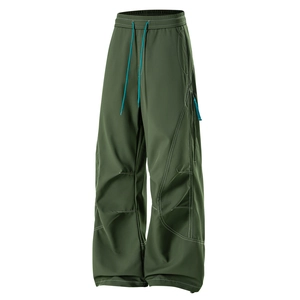 Détail du pantalon cargo vert foncé avec cordon bleu et coutures blanches contrastées