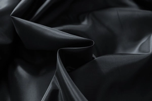 Gros plan détaillé du tissu noir de la veste à rayures avec une finition lisse et luisante