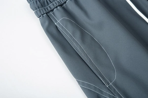 Détail du pantalon de plein air gris anthracite avec coutures blanches et taille élastique