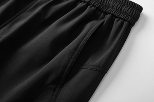 Vista macro dell'elastico in vita e della tasca laterale rinforzata dei pantaloni cargo neri