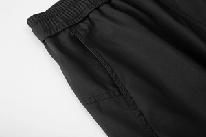 Dettaglio della vita elastica e delle cuciture rinforzate dei pantaloni cargo neri impermeabili
