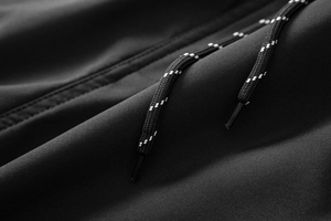 Vista macro di pantaloni cargo neri impermeabili con coulisse testurizzate e puntali opachi