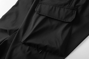 Dettaglio dei pantaloni cargo impermeabili con tasca tattica a patta e anello a D funzionale