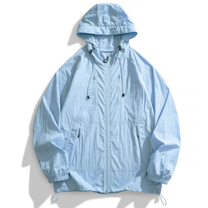 Close-up of light blue sun protection jacket with hood, dual chest zippers and nylon texture