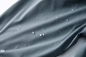 Détail macro du tissu imperméable avec gouttes d'eau sur un pantalon de plein air