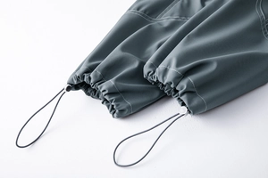 Détail du bas de pantalon cargo extérieur avec cordon réglable et coutures contrastées
