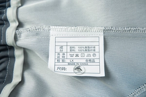 Gros plan détaillé sur l'étiquette d'entretien et de taille du pantalon gris de sport