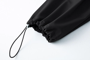Dettaglio dei pantaloni tattici impermeabili con cordoncino elastico e fibbia regolabile