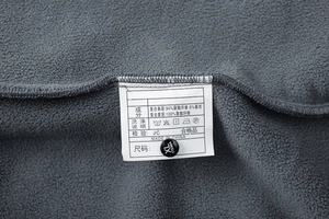 Detail of the washing label showing fleece material composition and size tag on the jacket