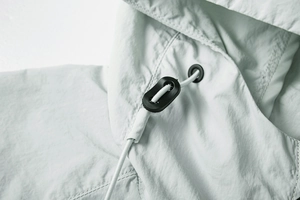 Close-up of lightweight jacket hood with elastic drawstring and black cord lock detail