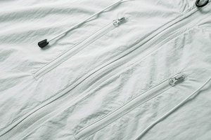 Detail showing high-quality waterproof nylon fabric and zipper pockets on outdoor jacket