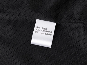 Detail view of black mesh fabric lining and 100% polyester wash label on outdoor vest