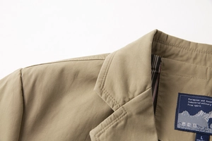 Dettaglio del colletto del blazer in cotone kaki con cuciture fini e fodera a righe blu