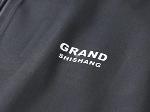 Detailed view of dark grey outdoor vest fabric with zipper and white brand logo