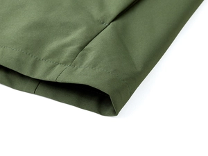 Detail of army green outdoor vest showing reinforced hem stitching and windproof fabric