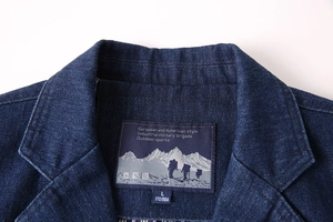Gros plan du col de blazer en jean avec étiquette de marque tissée et étiquette de taille
