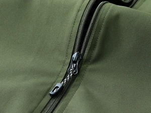 Macro detail of the high-density waterproof fabric and durable black zipper on the army green vest