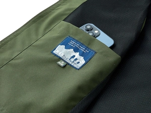 Detail of army green vest inner pocket with blue size label and black mesh lining