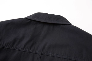 Dettaglio delle cuciture pulite e della trama del colletto di un blazer nero casual