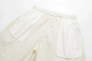 Detail of cream casual shorts showing elastic drawstring waist and large side pockets