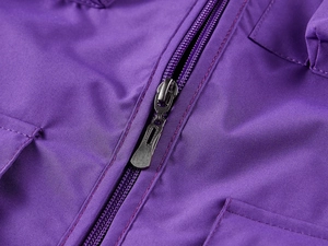 Détail de la fermeture éclair métallique et des poches latérales sur le gilet outdoor mauve