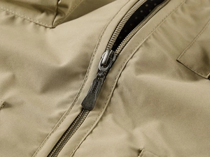 Gros plan du gilet extérieur kaki montrant la fermeture éclair en métal et le tissu durable