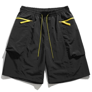 Detail of men cargo shorts with yellow drawstrings and contrasting side zipper pockets