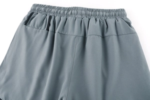 Detail view of elastic waistband and hidden zipper pocket on quick-dry sports shorts