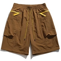 Detail of coffee brown cargo shorts with yellow zip pockets and elastic drawstring waist