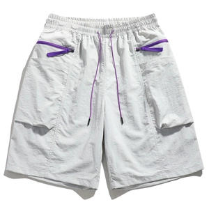 Detail of light gray cargo shorts featuring purple drawstring and decorative zipper pocket