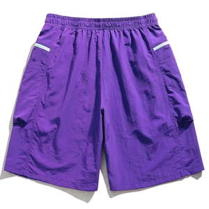Detail view of purple cargo shorts featuring elastic waist and large side flap pockets