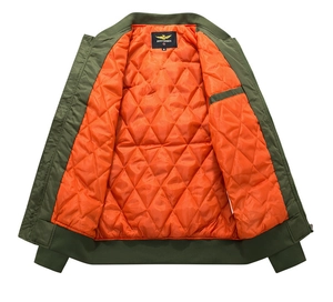 Detail der Bomberjacke in Armeegrün mit orangefarbenem Steppfutter und Rippbündchen