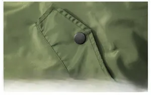 Detailweergave van de zijzak van het militaire groene bomberjack met zwarte knoop