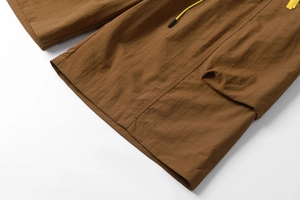 Detail view of khaki cargo shorts showing yellow drawstring and quick-dry fabric texture