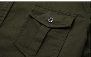Macro view of olive green military cotton shirt pocket with button detail and stitching