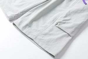Close-up of light gray cargo shorts featuring durable stitching and a 3D side patch pocket