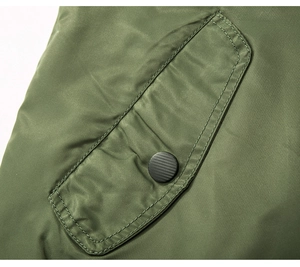 Detail der Armeegrünen Bomberjacke mit mattem Metall-Druckknopf und Nylon-Gewebe-Struktur