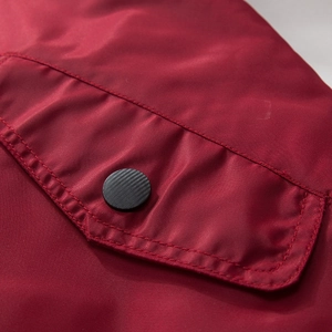 Detail of red windproof fabric with snap button on the envelope pocket of flight jacket