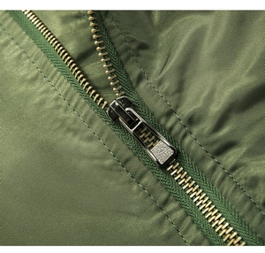 Detailansicht einer olivgrünen Jacke mit dichtem Stoff und hochwertigem Metallreißverschluss