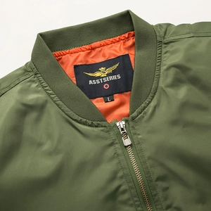 Detail of ribbed collar and orange lining on olive green bomber jacket with metal zipper