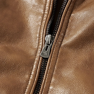 Detail of vintage brown leather jacket featuring a premium metal zipper with logo