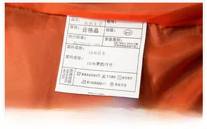 Detail of bomber jacket washing label showing 100% nylon fabric and orange lining