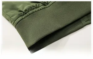 Detail shot of army green bomber jacket featuring a ribbed knit hem and windproof fabric