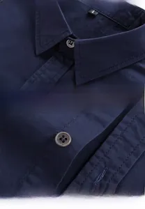 Detail of dark blue military shirt collar and buttons with high-density cotton texture