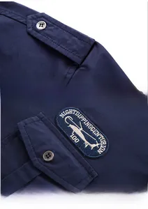 Detail of navy blue cotton military shirt featuring shoulder epaulettes and circular helicopter badge