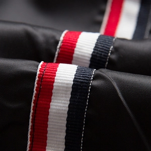 Detail of red white and blue striped grosgrain ribbon on premium black twill fabric