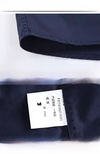 Detailed view of navy cotton shirt stitching, chest pocket, and fabric texture