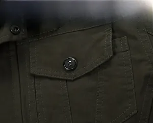 Detailed close-up of dark green cotton utility jacket featuring a flap chest pocket with button